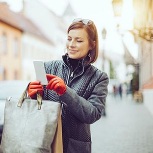 Femme faisant une détaxe sur son téléphone après avoir fait du shopping en France