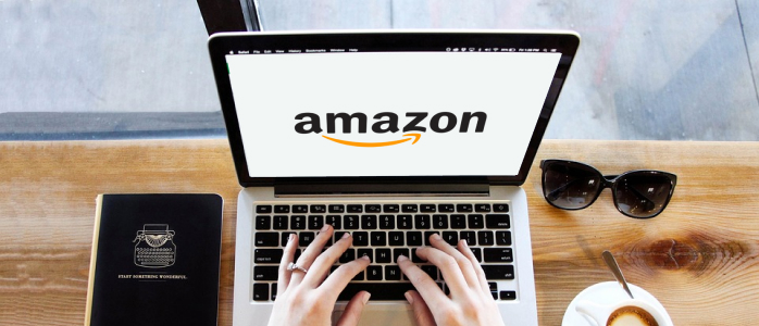 Une personne tape sur un ordinateur sur lequel le logo d'Amazon France apparait